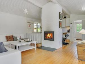 ein Wohnzimmer mit einem Kamin und einem Sofa in der Unterkunft Holiday Home Tobrjön - 200m to the inlet in Sealand by Interhome in Skibby