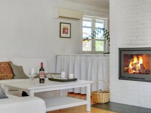 una sala de estar con chimenea y una mesa con una botella de vino en Holiday Home Tobrjön - 200m to the inlet in Sealand by Interhome, en Skibby