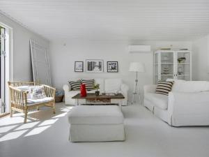 una sala de estar blanca con un sofá blanco y sillas en Holiday Home Kaino - 700m from the sea in Sealand by Interhome, en Gilleleje