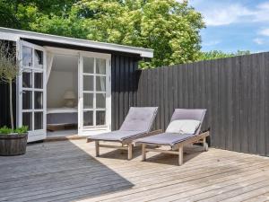 2 sillas en una terraza de madera con una valla en Holiday Home Kaino - 700m from the sea in Sealand by Interhome, en Gilleleje