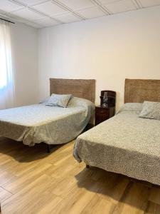 - une chambre avec 2 lits et du parquet dans l'établissement Vivienda rural Vega del Guadalquivir, à Villacarrillo