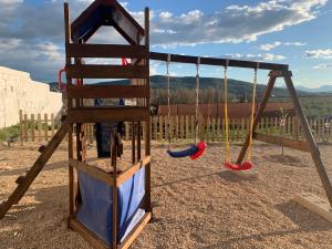 un columpio con tres columpios en un parque infantil en Vivienda rural Vega del Guadalquivir, en Villacarrillo