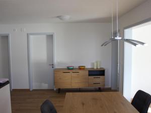 Apartment Pardi 3 Simeon by Interhome في Lenz: غرفة طعام مع طاولة وخزانة خشبية