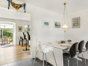 een witte eetkamer met een witte tafel en stoelen bij Holiday Home Rebana - 30m from the sea in Sealand by Interhome in Hundested