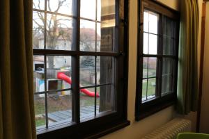 una ventana con vistas a un patio de recreo visto a través de él en Jugendherberge Dinkelsbühl - Youth Hostel en Dinkelsbühl