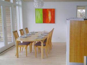 een eettafel met stoelen en een schilderij aan de muur bij Holiday Home Vicente - 130m from the sea in Sealand by Interhome in Jægerspris