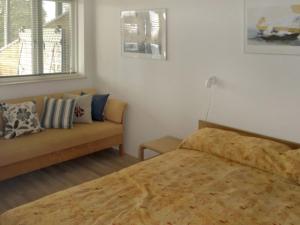 um quarto com uma cama e um sofá em Holiday Home Vicente - 130m from the sea in Sealand by Interhome em Jægerspris