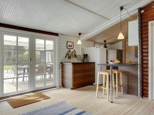 a kitchen with a table and chairs in a room at Holiday Home Hjort - 100m from the sea in Sealand by Interhome in Dronningmølle