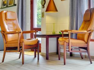- deux chaises orange et une table dans une chambre dans l'établissement Holiday Home Merita - 1-1km from the sea in Sealand by Interhome, à Eskebjerg