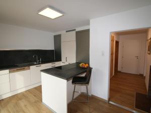 a kitchen with white cabinets and a black counter top at Apartment Lisa by Interhome in Wiesing