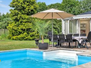 patio con tavolo e ombrellone accanto alla piscina di Holiday Home Fentje - 375m to the inlet in Sealand by Interhome a Grevinge