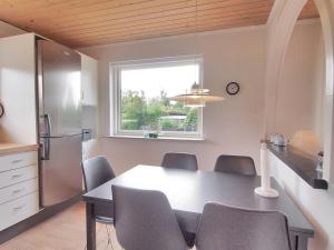 a kitchen and dining room with a table and chairs at Holiday Home Jasper - 175m to the inlet in Sealand by Interhome in Karrebæksminde