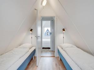 ゲッサーにあるHoliday Home Mijat - 100m from the sea in Lolland- Falster and Mon by Interhomeのベッド2台と窓が備わる屋根裏部屋です。