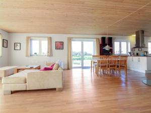 Apartment Ettie - 6km from the sea in Sealand by Interhome في Faxe: غرفة معيشة ومطبخ مع أريكة وطاولة