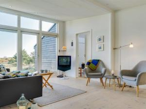 uma sala de estar com um sofá e cadeiras e uma televisão em Holiday Home Helin - 100m from the sea in Sealand by Interhome em Yderby