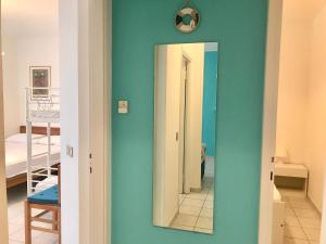 a blue room with a mirror and a bedroom at Condominio Leda in Bibione