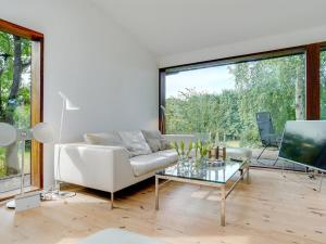 ein Wohnzimmer mit einem weißen Sofa und einem Glastisch in der Unterkunft Holiday Home Erikka - 300m to the inlet in Sealand by Interhome in Holbæk