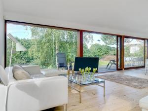 - un salon avec un canapé blanc et une table en verre dans l'établissement Holiday Home Erikka - 300m to the inlet in Sealand by Interhome, à Holbæk