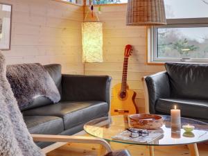 - un salon avec un canapé et une table avec une guitare dans l'établissement Holiday Home Gundhild - all inclusive - 1-8km from the sea by Interhome, à Fårevejle