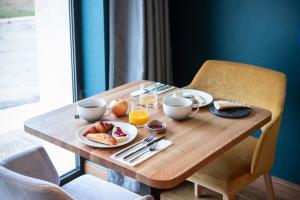 - une table en bois avec des aliments pour le petit-déjeuner dans l'établissement Ezia, à Montlivault