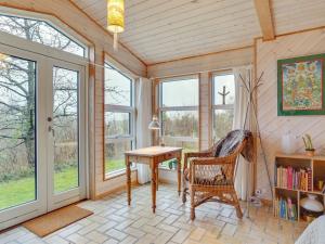 Cette chambre comprend une table, des chaises et des fenêtres. dans l'établissement Holiday Home Gundhild - all inclusive - 1-8km from the sea by Interhome, à Fårevejle