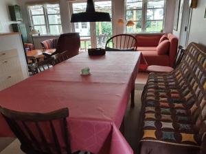 uma sala de estar com uma mesa rosa e cadeiras em Holiday Home Haldis - 120m from the sea in Lolland- Falster and Mon by Interhome em Stubbekøbing