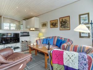 een woonkamer met 2 banken en een tafel bij Holiday Home Haldis - 120m from the sea in Lolland- Falster and Mon by Interhome in Stubbekøbing
