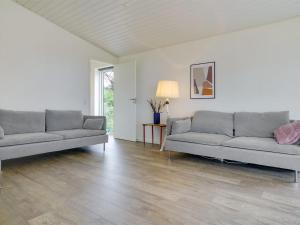 ein Wohnzimmer mit 2 Sofas und einem Tisch in der Unterkunft Holiday Home Gjorgje - 100m from the sea in Sealand by Interhome in Tjørneholm