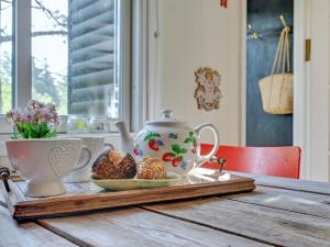 - une table avec une théière et des muffins dans l'établissement Holiday Home Claudine - 300m from the sea in Sealand by Interhome, à Tjørneholm