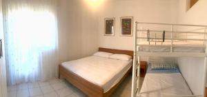 a small room with two bunk beds and a window at Condominio Leda in Bibione