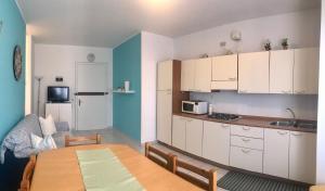 a kitchen with white cabinets and a table in a room at Condominio Leda in Bibione