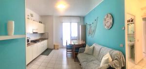 a living room with a couch and a kitchen at Condominio Leda in Bibione +21 photos