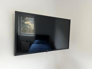 a flat screen tv hanging on a wall at Wochenzimmer - Premium Apartments für Monteure, Event- und Projektteams in Sankt Peter-Freienstein