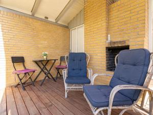 une terrasse couverte avec 2 chaises, une table et un mur en briques dans l'établissement Holiday Home Janin - 210m from the sea in Lolland- Falster and Mon by Interhome, à Rødby