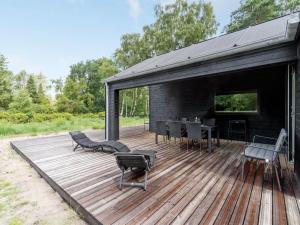 eine Holzterrasse mit Stühlen und einem Tisch darauf in der Unterkunft Holiday Home Ella - 1-2km to the inlet in Sealand by Interhome in Rørvig