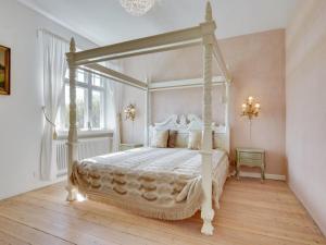 1 dormitorio con cama blanca con dosel en una habitación en Holiday Home Kadri in Sealand by Interhome, en Karise