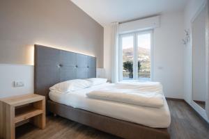una camera da letto con un letto grande con una grande finestra di Hotel Rolly a Riva del Garda