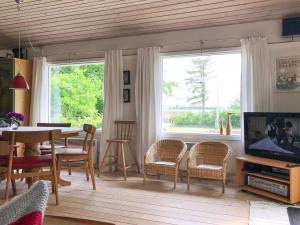 sala de estar con mesa, sillas y TV en Holiday Home Vojo - 100m from the sea in Lolland- Falster and Mon by Interhome en Stubbekøbing
