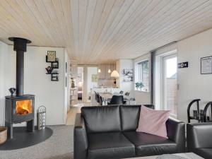 - un salon avec un canapé et une cheminée dans l'établissement Holiday Home Gisl - 400m from the sea in Funen by Interhome, à Bogense