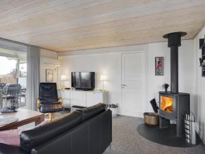 - un salon avec un canapé et une cheminée dans l'établissement Holiday Home Gisl - 400m from the sea in Funen by Interhome, à Bogense