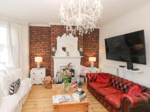 uma sala de estar com um sofá vermelho e um lustre em Stunning Large Victorian Townhouse em Cardiff