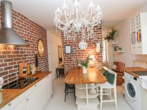 uma cozinha com uma mesa e uma parede de tijolos em Stunning Large Victorian Townhouse em Cardiff
