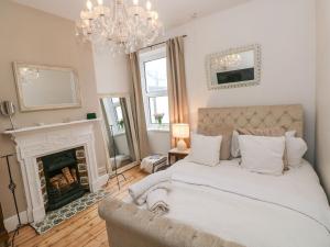 um quarto com uma cama grande e uma lareira em Stunning Large Victorian Townhouse em Cardiff