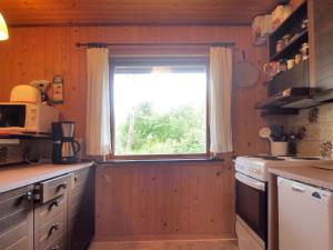 uma cozinha com uma janela numa cozinha de madeira em Holiday Home Thing - 200m from the sea in Lolland- Falster and Mon by Interhome em Askeby