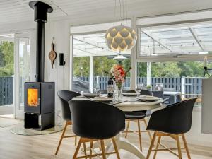 a dining room with a table and chairs and a fireplace at Holiday Home Dierf - 550m from the sea by Interhome in Gedser +14 photos