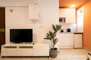 a living room with a tv on a white cabinet at Lodging Apartments Barceloneta Mar in Barcelona