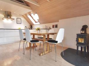 uma cozinha com uma mesa e cadeiras de madeira e um fogão em Holiday Home Elbert - 100m from the sea in Funen by Interhome em Otterup