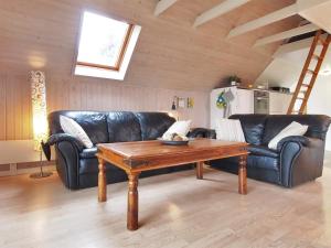uma sala de estar com um sofá de couro e uma mesa de madeira em Holiday Home Elbert - 100m from the sea in Funen by Interhome em Otterup