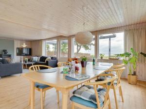 een woonkamer met een houten tafel en stoelen bij Holiday Home Sigurd - 20m from the sea in Funen by Interhome in Middelfart