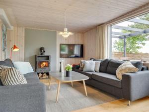 a living room with a couch and a fireplace at Holiday Home Sigurd - 20m from the sea in Funen by Interhome in Middelfart